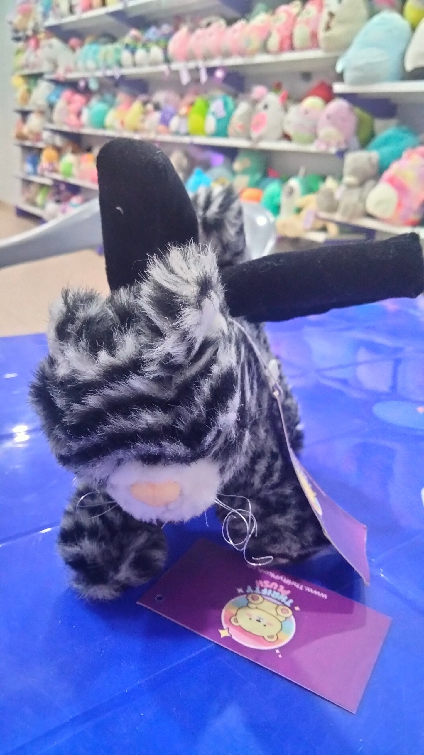 This is a grey and black striped plush cat toy